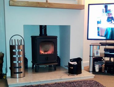 Log burner installed in a living room fireplace in Wigan